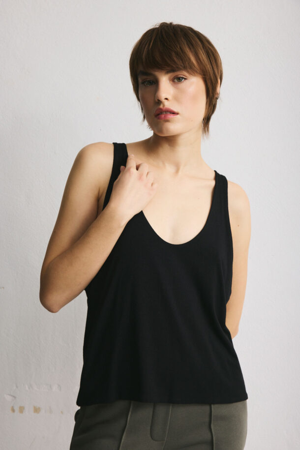 Black viscose top with sharply cut armholes.